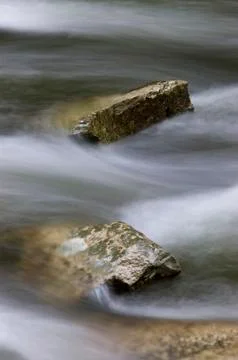 Pair of rocks in a rushing river 스톡 사진