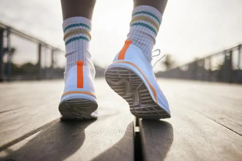 A pair of running shoes being warn. An African American man is moving forward on Fotos Stock