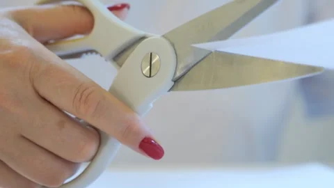 Pair of scissors is being used to cut a piece of paper Stock Footage 327791803