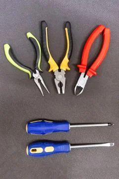 Pair of screwdrivers rubber handles parallel hand tools three pliers pliers Stock Photos