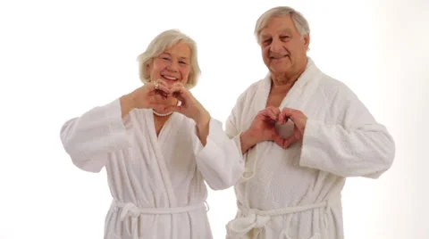 A pair of seniors forms a heart with their hands. Stock Footage 24634396
