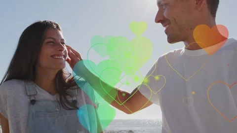 Pair sharing smiles, man brushing her hair, floating hearts between them over Vídeo Stock 333911023