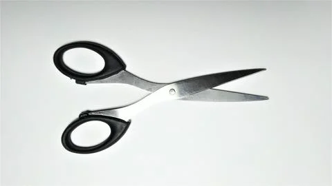 A pair of sharp metal scissors with black plastic handles isolated on a whi.. Stock Photos