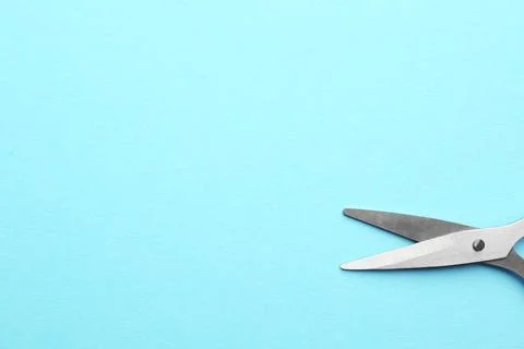 Pair of sharp scissors on color background, top view. Space for text Foto stock
