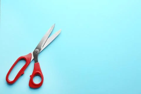 Pair of sharp scissors on color background, top view. Space for text Stock Photos