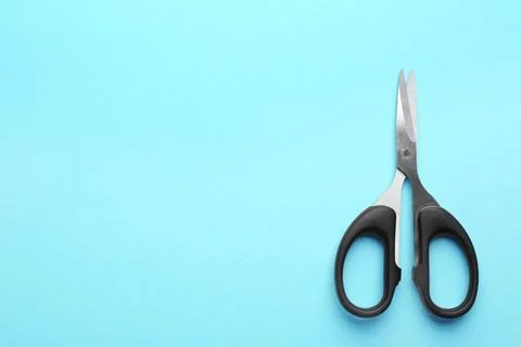 Pair of sharp scissors on color background, top view. Space for text Stock Photos