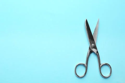 Pair of sharp scissors on color background, top view. Space for text Stock Photos