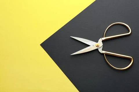 Pair of sharp scissors on color background, top view. Space for text Stock Photos