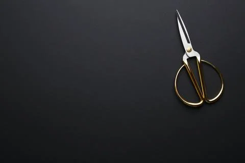 Pair of sharp scissors on dark background, top view. Space for text Stock Photos