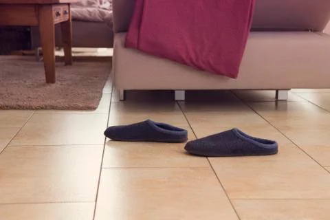 Pair of slippers next to a couch Foto stock