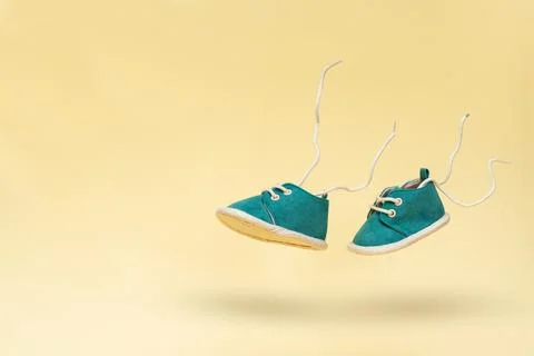 A pair of small children's shoes float in the air. The concept of a carefree Stock Photos