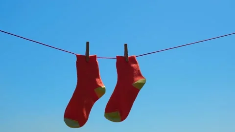 Pair of socks closeup drying after washing on rope, swaying in wind against sky. Stock Footage 225681753