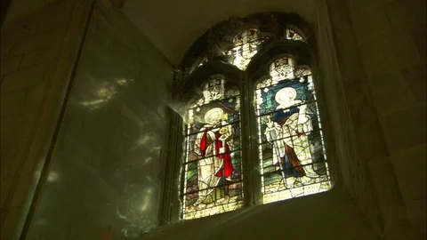 Pair of stained glass windows with light reflecting on stone walls Video stock 95605331