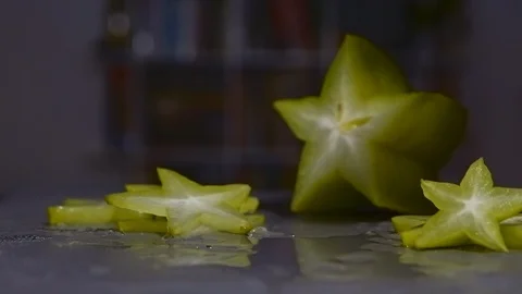 The pair taking one piece of starfruit with seeds. Fight for sliced fruit, hands Stock Footage 125639401