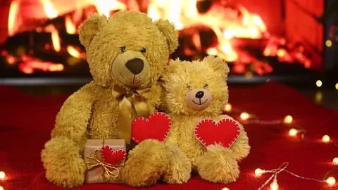 Pair of teddy bears are sitting hugging against the background of a red knitted Stock Footage 168387730