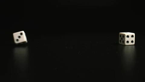 Pair of thrown dices on black background, close up. White Dices rolling. Stock Footage 146316452