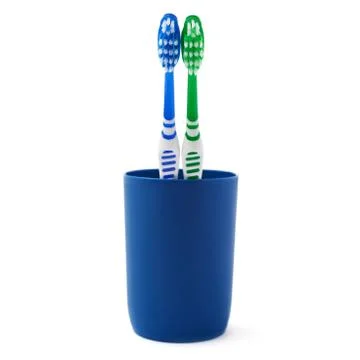 Pair of toothbrushes in blue plastic cup isolated over white background Fotos Stock