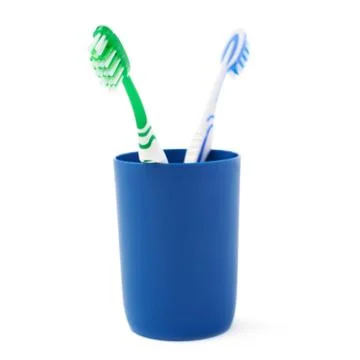 Pair of toothbrushes in blue plastic cup isolated over white background Fotos Stock