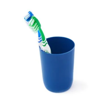 Pair of toothbrushes in blue plastic cup isolated over white background Fotos Stock