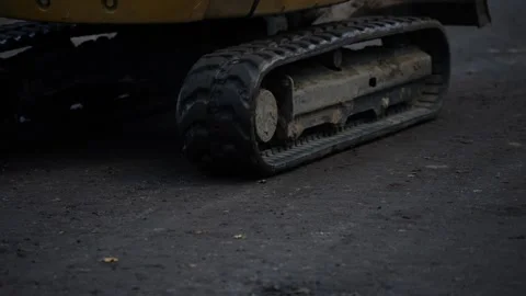 Pair of tracked undercarriages on compact construction machine, highlighting Stock Footage 320804030