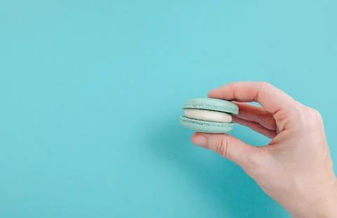 Pair of turquoise macarons on solid turquoise background, teal monochrome f.. Stock Photos