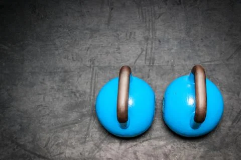 Pair of two old heavy iron kettlebells on the gym floor Foto stock