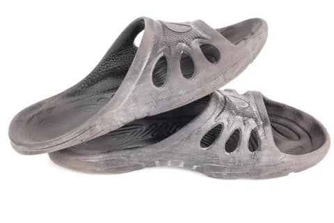 Pair of used cheap black soft rubber slippers with signs od friction wear Фото