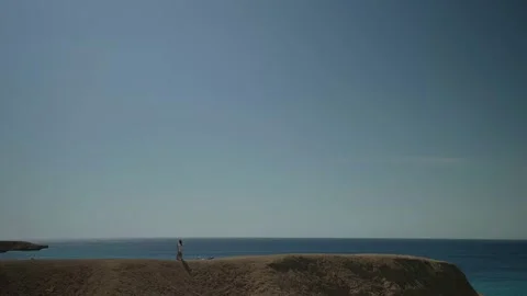 Pair is walking at top of cliff over sea, amazing nature with sea, sky and Видео 163364946