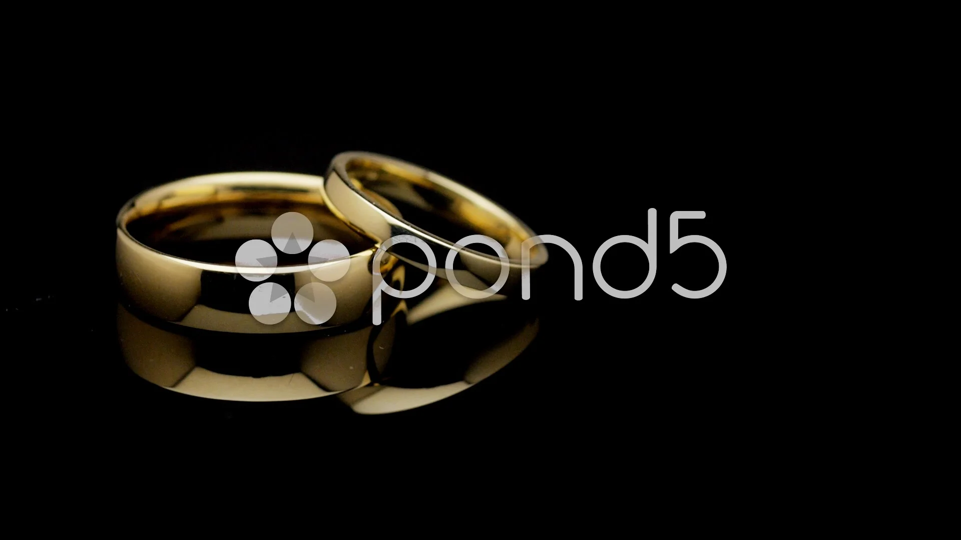 Pair of wedding rings turning on black | Stock Video | Pond5
