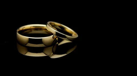 Bạn đang tìm kiếm một chiếc nhẫn cưới đen phong cách? Hãy xem ngay hình ảnh này của chúng tôi. Nhẫn cưới đang quay trên nền đen được ghi lại một cách chân thực và đẹp mắt. Bạn sẽ không hối hận khi chọn chiếc nhẫn này cho ngày trọng đại của mình. 