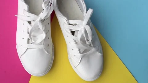 A pair of white sneakers on a colored background. Fashion footwear. Stock Footage 221814014