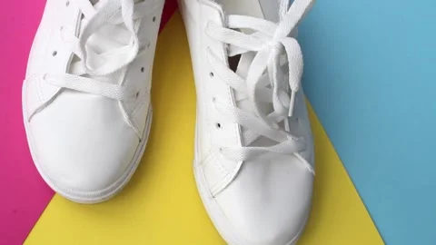 A pair of white sneakers on a colored background. Fashion footwear. Stock Footage 250956470