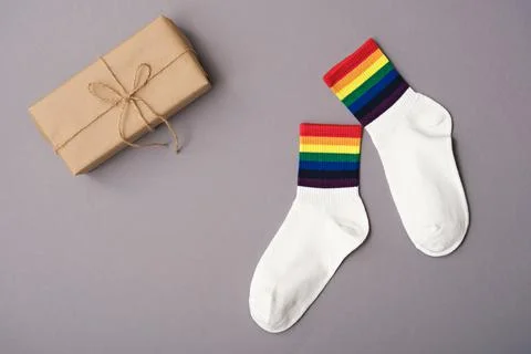 Pair of white socks with rainbow edging and gift box on gray background, idea Stock Photos