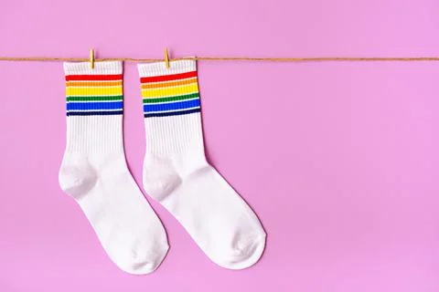 Pair of white socks with rainbow edging on pink background Stock Photos
