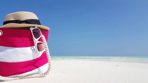 A pair of white sunglasses and a hat rest on top of a nautical patterned 스톡 동영상 118185908
