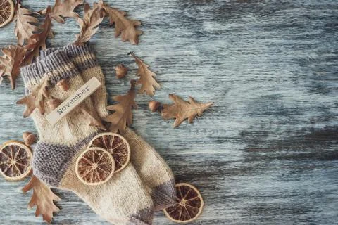 Pair of woolen socks and different dry decorations, wooden background Stock Photos
