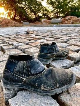 Pair of worker's boots abandoned at dusk Stock Photos