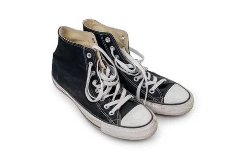 Pair of worn black old school sneakers isolated on white background. Stock Photos