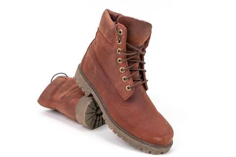 Pair of worn brown leather boots isolated on white background. Stock Photos