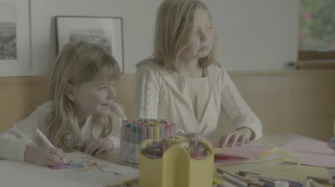 A pair of young sisters listen to instructions then return to drawing. Stock Footage 68350301