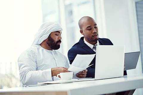 Paired up to pull off a successful project. two businessmen using a digital Stock Photos