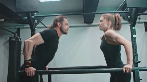 Paired push-ups on the uneven bars in the gym. Stock Footage 153587942