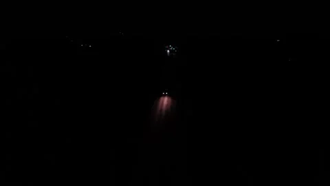 Pairs of bright car headlights and glowing red taillights streak along straight Stock Footage 346570042