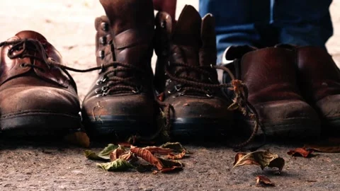 Pairs of dirty old boots for work close up Stock Footage 248536096