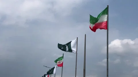 Pakistan and Iran two flags on flagpoles and blue cloudy sky 스톡 동영상 344649543