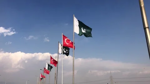 Pakistan and Turkey two flags on flagpoles and blue cloudy sky, waving colorful  스톡 동영상 344650190
