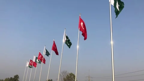 Pakistan and Turkey two flags on flagpoles and blue cloudy sky, waving colorful  스톡 동영상 344651372