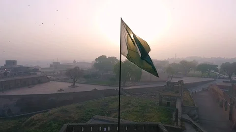 Pakistan Flag with sunrise and old lahore in the background Stock Footage