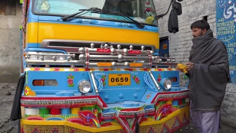 Pakistani man cleaning decorations on the front of his Jingle Truck Stock Footage 132927465