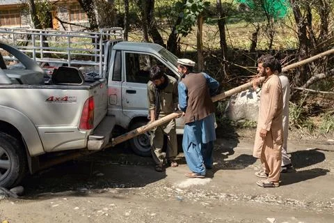 Pakistani men pull out stuck car in pakistani village Chitral valley Stock Photos